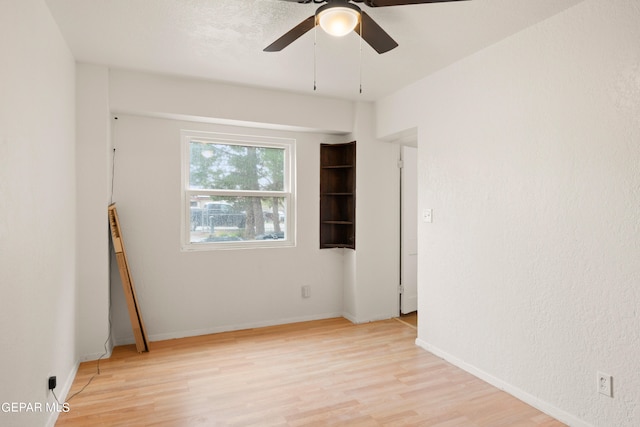 empty room with ceiling fan and light hardwood / wood-style floors