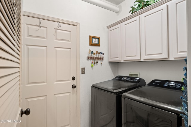 laundry room with cabinets and washer and clothes dryer