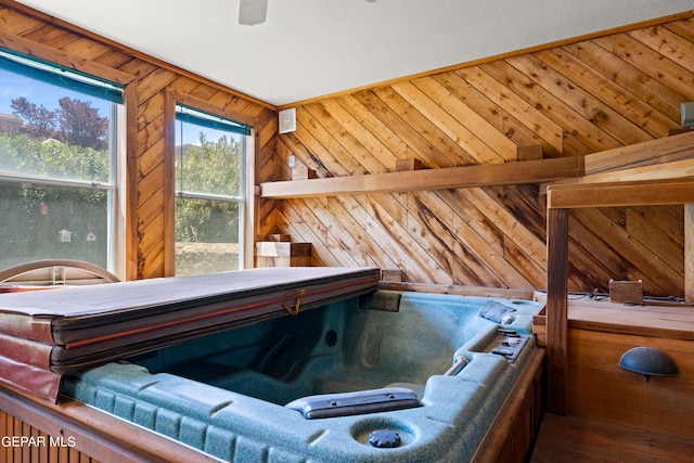 interior space with a hot tub, wooden walls, and hardwood / wood-style flooring