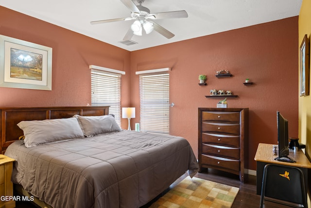 bedroom with ceiling fan and dark hardwood / wood-style floors