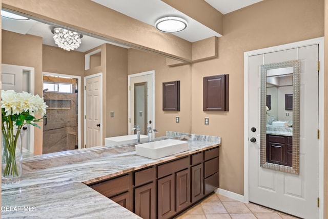 bathroom with tile patterned flooring, walk in shower, and vanity