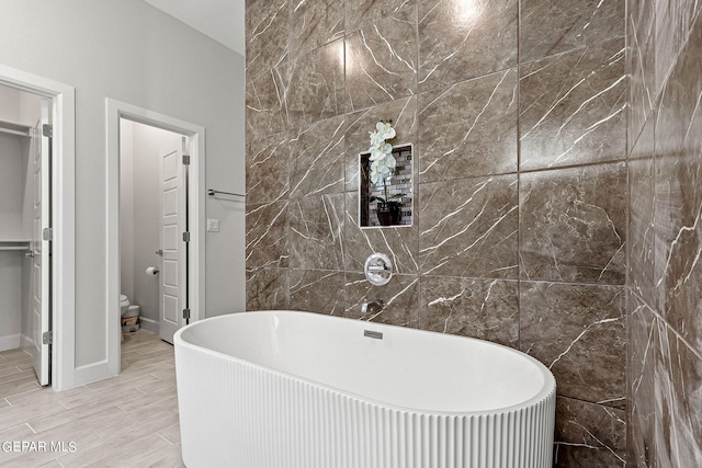 bathroom featuring tile walls and a bathing tub