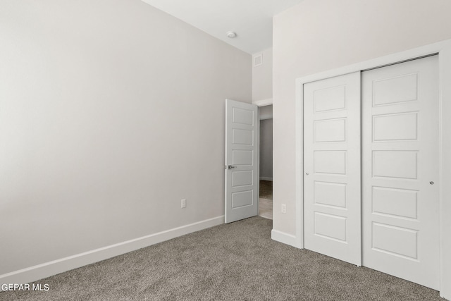 unfurnished bedroom featuring carpet flooring and a closet