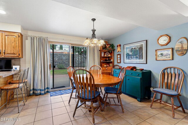 dining room featuring lofted ceiling, a textured ceiling, a chandelier, and light tile patterned flooring