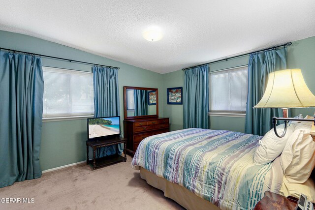 bedroom featuring lofted ceiling, carpet flooring, and a textured ceiling