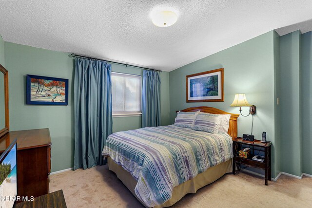 carpeted bedroom with lofted ceiling and a textured ceiling