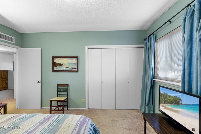 carpeted bedroom featuring a closet and a textured ceiling