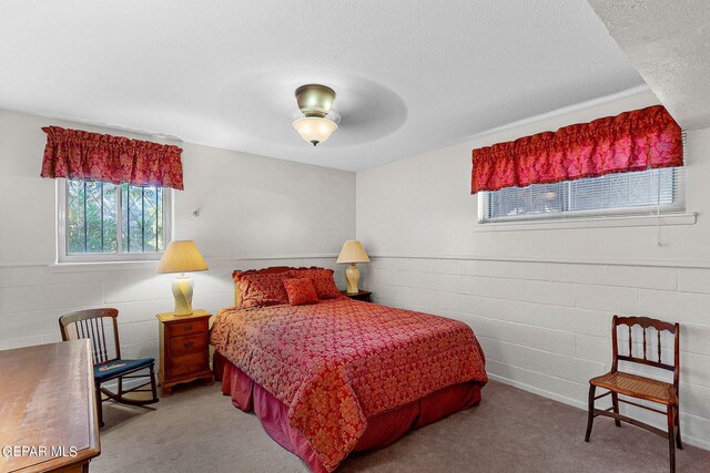 bedroom with a textured ceiling, ceiling fan, and carpet