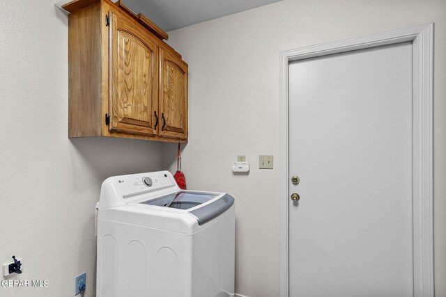 clothes washing area with cabinets and washer / dryer