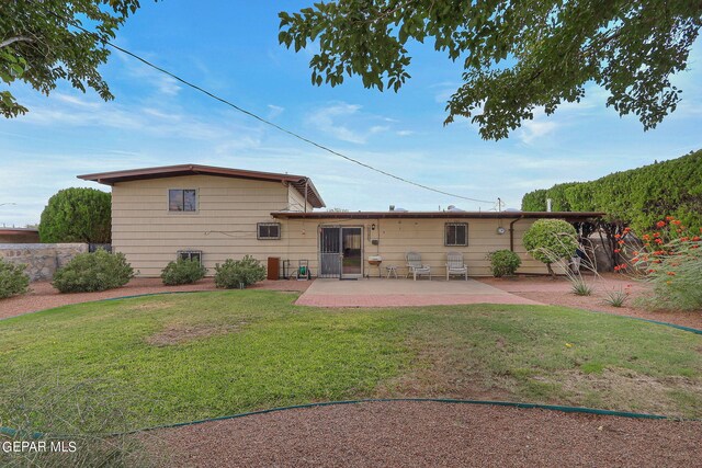 back of house with a lawn and a patio