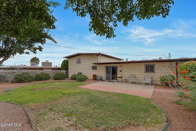 rear view of house with a yard and a patio area