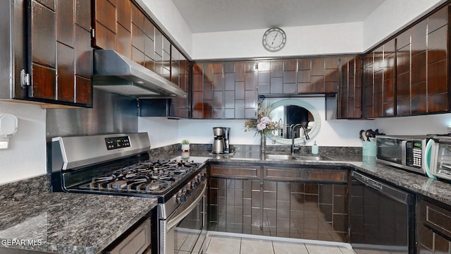 kitchen featuring dark stone counters, sink, appliances with stainless steel finishes, light tile patterned flooring, and dark brown cabinetry