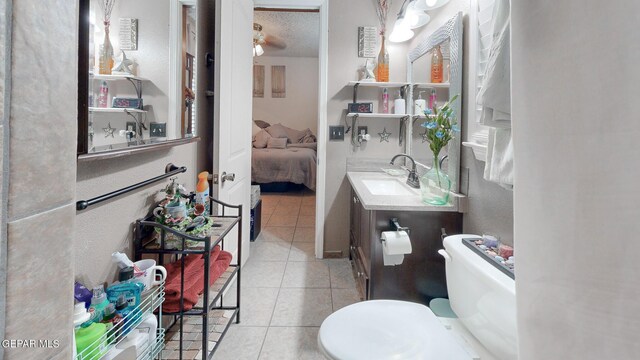 bathroom with tile patterned floors, toilet, a textured ceiling, and vanity