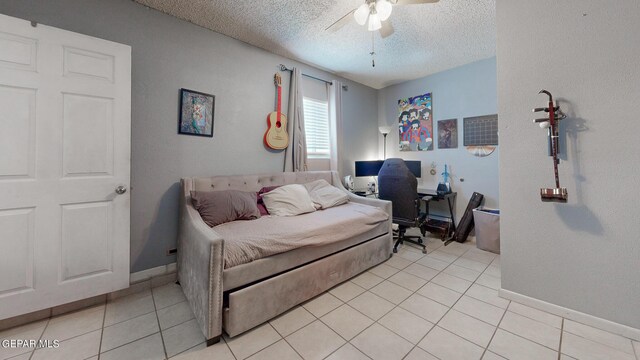 tiled bedroom with a textured ceiling and ceiling fan