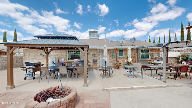 view of patio / terrace with an outdoor fire pit, a grill, and a gazebo