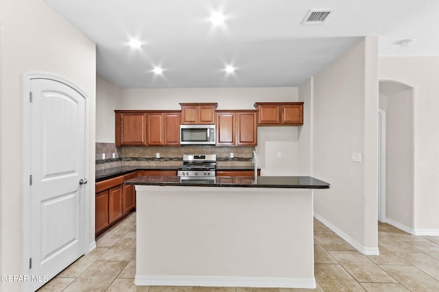 kitchen featuring dark countertops, visible vents, appliances with stainless steel finishes, and brown cabinets