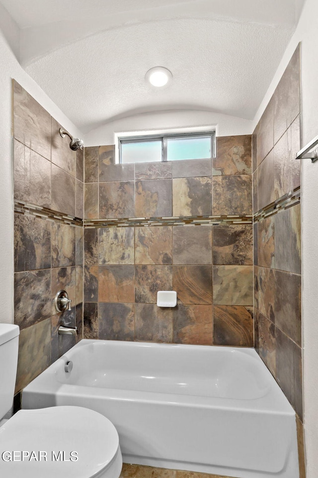 full bath featuring vaulted ceiling, toilet, shower / bathtub combination, and a textured ceiling