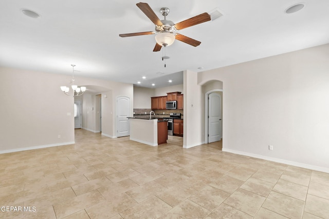 unfurnished living room featuring ceiling fan with notable chandelier and sink