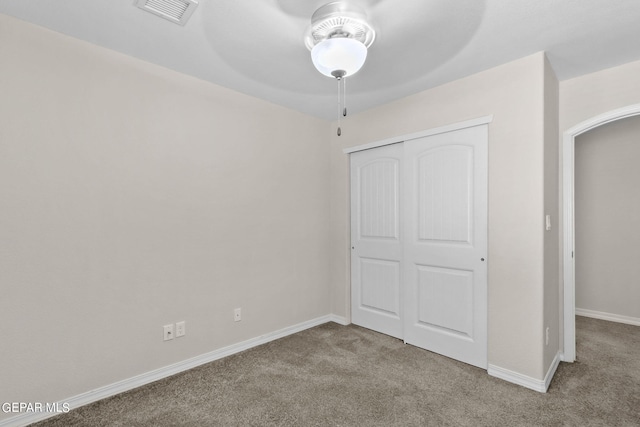 unfurnished bedroom featuring a closet, ceiling fan, and carpet