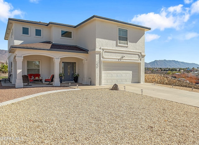 view of front of home with a mountain view, a porch, and a garage