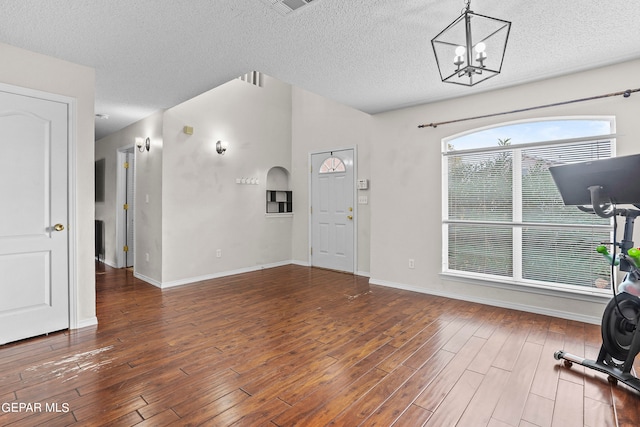 interior space with dark wood-type flooring, a wealth of natural light, and a textured ceiling