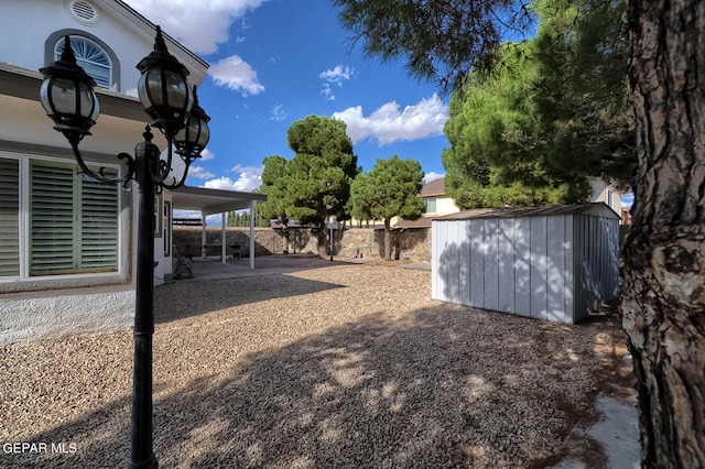 view of yard featuring a shed and a patio