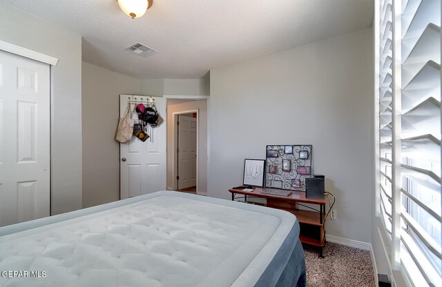 carpeted bedroom featuring a textured ceiling