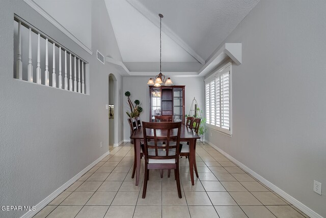 tiled dining area featuring lofted ceiling and an inviting chandelier