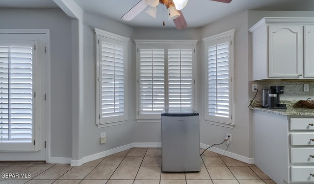 unfurnished dining area featuring ceiling fan and light tile patterned floors