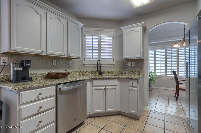 kitchen with light stone counters, sink, white cabinetry, and stainless steel dishwasher