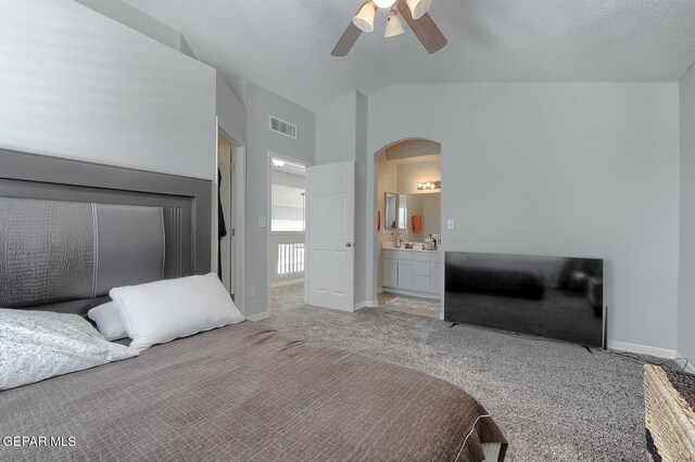 carpeted bedroom with high vaulted ceiling, ceiling fan, connected bathroom, and a textured ceiling