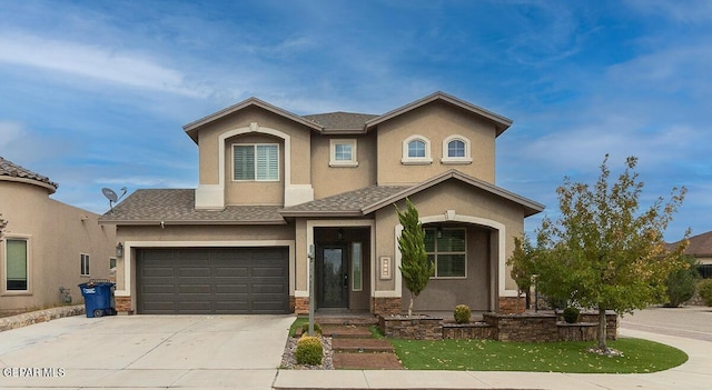 view of front of house with stucco siding, an attached garage, concrete driveway, and a shingled roof