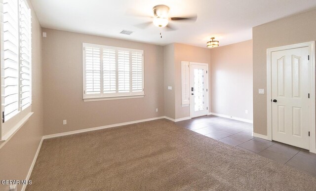 carpeted foyer entrance featuring ceiling fan