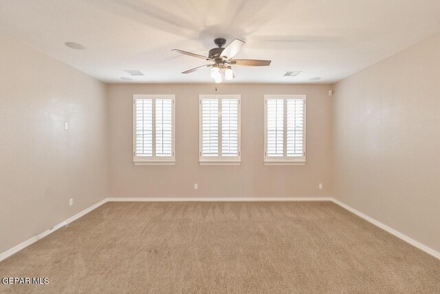 carpeted spare room with a healthy amount of sunlight and ceiling fan