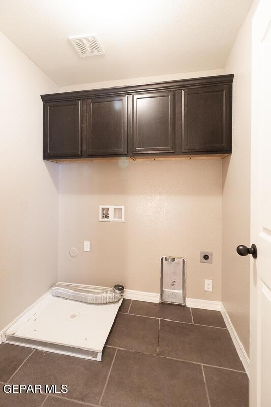 laundry area featuring washer hookup, dark tile patterned flooring, cabinets, and hookup for an electric dryer