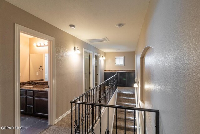 stairs featuring sink and tile patterned floors