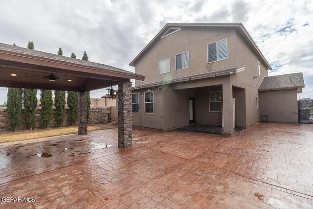 rear view of house with ceiling fan and a patio