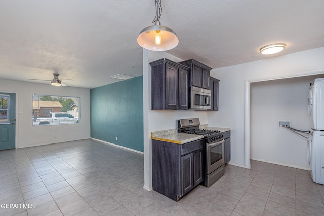 kitchen featuring stainless steel appliances, light tile patterned flooring, ceiling fan, dark brown cabinetry, and a textured ceiling