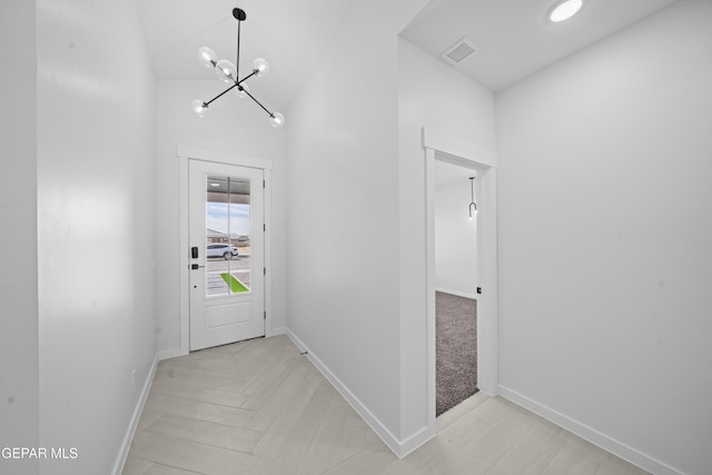 entryway with a chandelier, visible vents, and baseboards