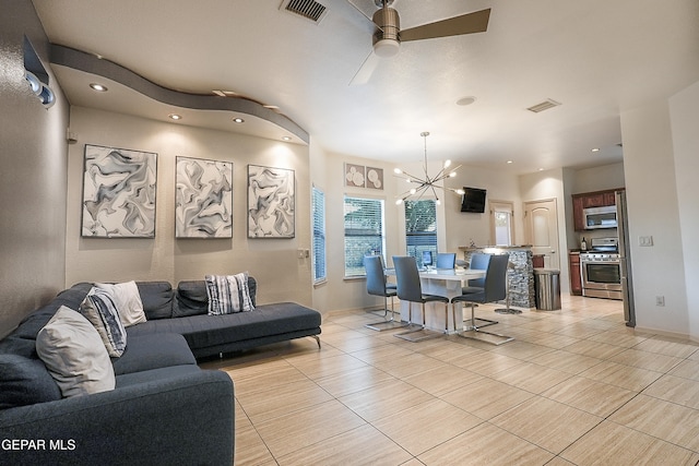 living room with ceiling fan with notable chandelier and light tile patterned floors