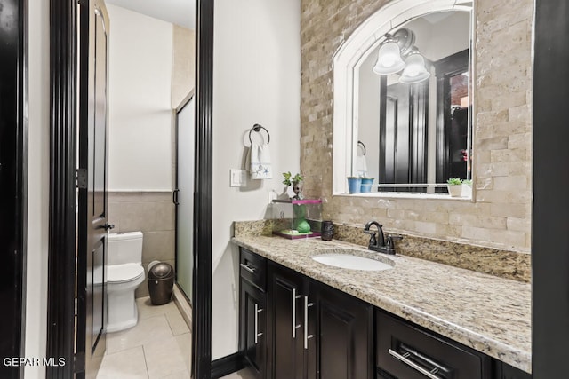 bathroom featuring tile patterned flooring, vanity, toilet, and an enclosed shower