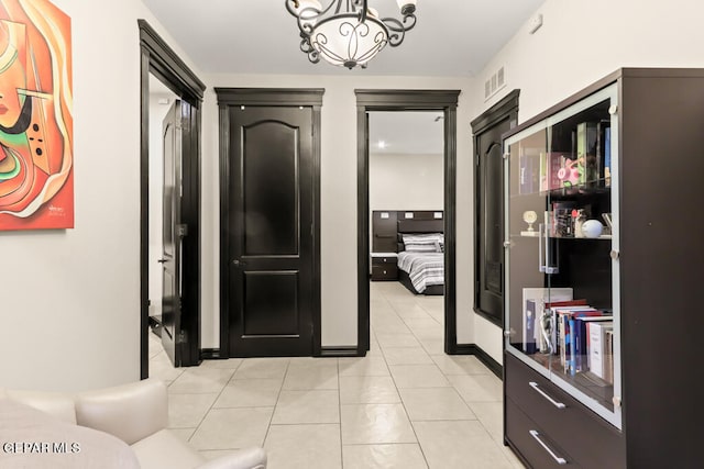 tiled foyer entrance with a chandelier