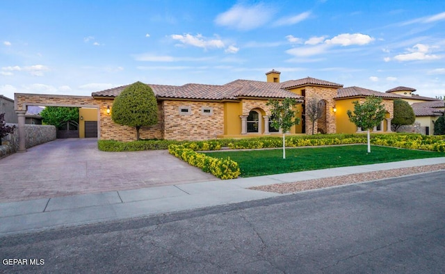 4500 Honey Willow Way, El Paso, TX 79922 - mediterranean / spanish-style home with decorative driveway, stucco siding, a front yard, a tiled roof, and stone siding