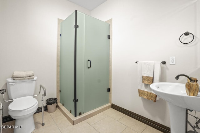 bathroom featuring tile patterned flooring, a shower with shower door, and toilet