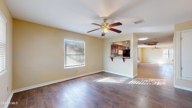 unfurnished room with wood-type flooring, plenty of natural light, and ceiling fan