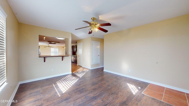 empty room with ceiling fan and dark hardwood / wood-style flooring