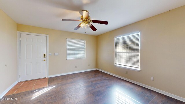 empty room with dark hardwood / wood-style floors and ceiling fan