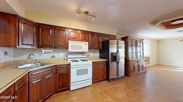 kitchen featuring sink, white appliances, decorative backsplash, light tile patterned floors, and ornamental molding