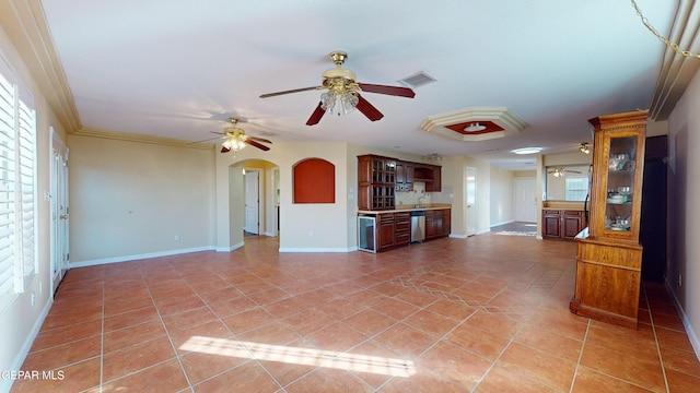 unfurnished living room featuring crown molding, tile patterned flooring, ceiling fan, and a healthy amount of sunlight