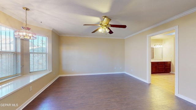 empty room with hardwood / wood-style floors, ceiling fan with notable chandelier, and crown molding